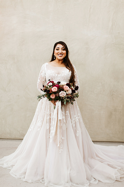 Orange county wedding at the estate on second bride lace ball gown with long sleeves and high neckline with crystal hair piece holding pink and red floral bridal bouquet