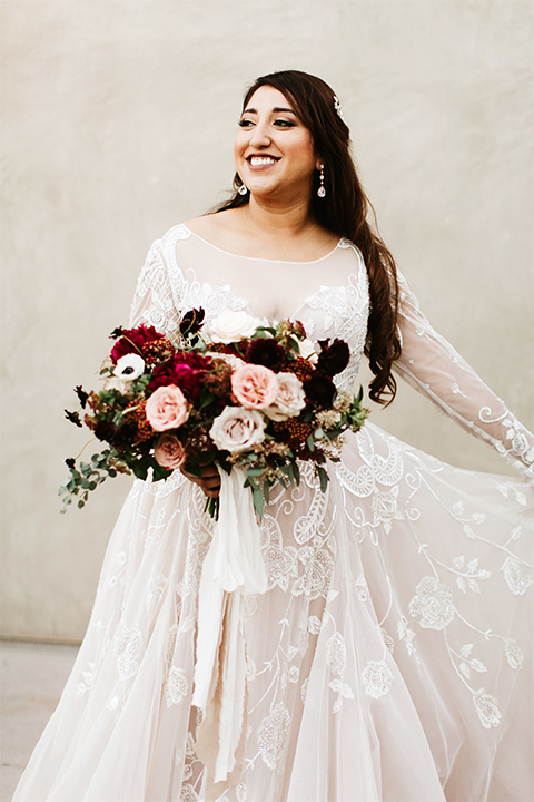 Orange county wedding at the estate on second bride lace ball gown with long sleeves and high neckline with crystal hair piece holding pink and red floral bridal bouquet holding dress