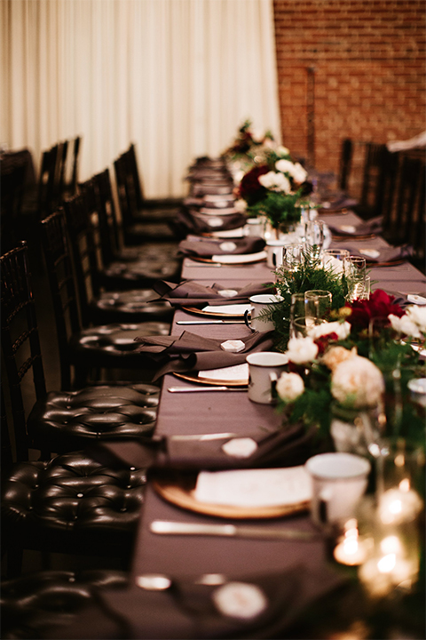 Orange county wedding at the estate on second dark brown wood table with gold place settings and white and green flower centerpiece decor with white glasses and candles and black chairs