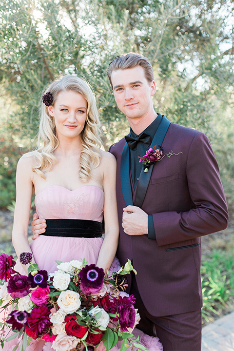Los angeles valentine theme wedding shoot at the gardens at los robles bride pink ballgown dress with ruffled skirt and dark pink and white floral bridal bouquet with groom burgundy tuxedo with black dress shirt and black bow tie with red floral boutonniere smiling