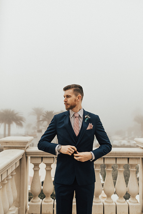 Dana point outdoor wedding shoot at monarch beach resort groom navy blue suit with matching vest and long blush pink striped tie and matching pocket square with floral boutonniere