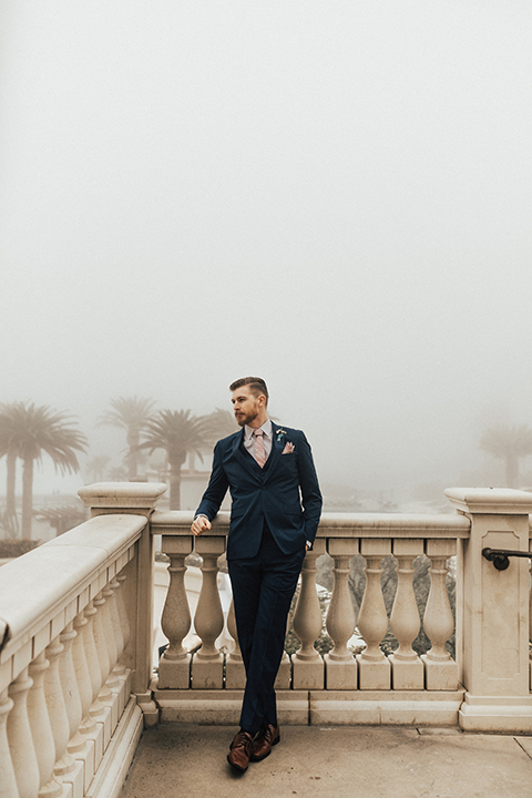 Dana point outdoor wedding shoot at monarch beach resort groom navy blue suit with matching vest and long blush pink striped tie and matching pocket square with floral boutonniere