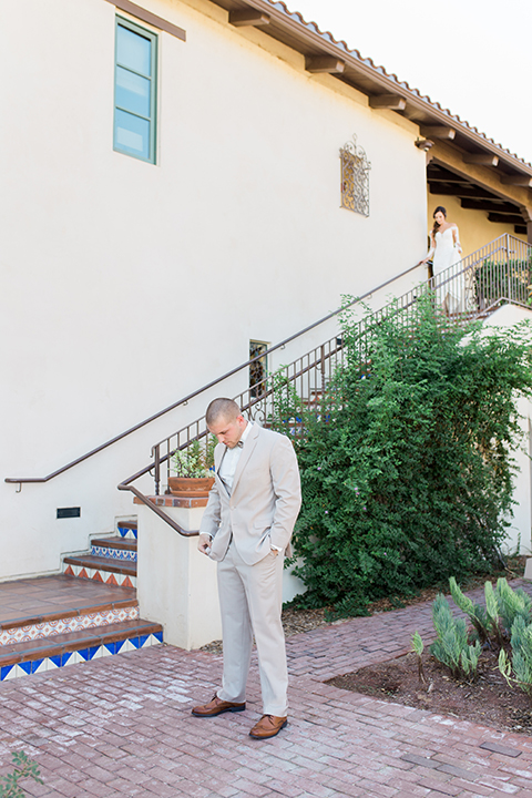 Temecula outdoor wedding at ponte winery groom tan suit with matching vest and white dress shirt with matching tan bow tie with white floral boutonniere