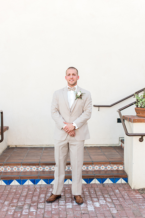 Temecula outdoor wedding at ponte winery groom tan suit with matching vest and white dress shirt with matching tan bow tie with white floral boutonniere