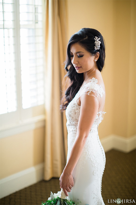 Downtown los angeles wedding bride form fitting lace gown with illusion back and high neckline with crystal hair piece wedding photo idea for bride holding white and green floral bridal bouquet