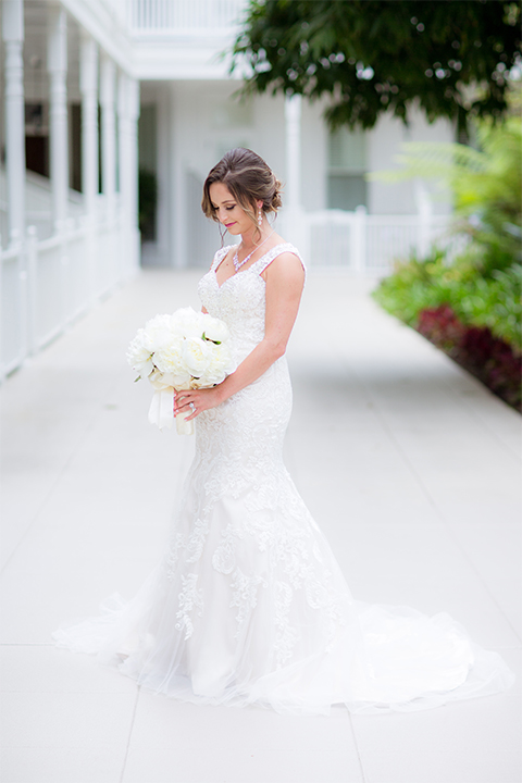 San diego wedding at the crossings carlsbad bride form fitting lace gown with thin straps and ruffled skirt with sweetheart neckline holding white floral bridal bouquet