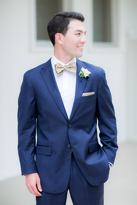 San diego wedding at the crossings carlsbad groom cobalt blue suit with white dress shirt and gold bow tie with matching pocket square and white floral boutonniere