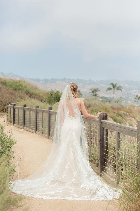 Los angeles wedding at los verdes golf club bride form fitting gown with lace detail and low back design with thin straps and long veil