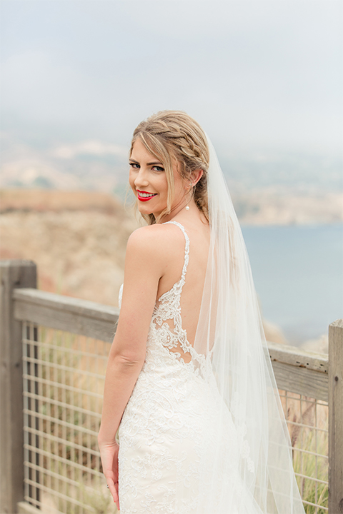 Los angeles wedding at los verdes golf club bride form fitting gown with lace detail and low back design with thin straps and long veil