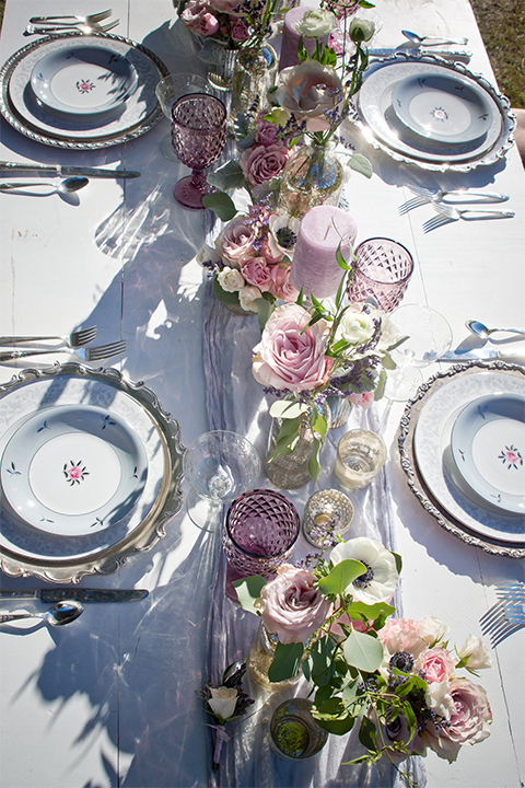 San diego outdoor woodland wedding shoot table set up white wood table with vintage decor and blush pink glassware with white and green flower centerpiece decor with white vintage benches and white place settings